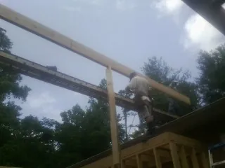 Carpenter setting a ridge beam over a new addition frame — Ice Dam Removal by Roofing Brothers in Monterey